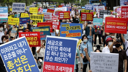 지난 25일 서울 중구 예금보험공사 앞에서 열린 '소급적용 남발하는 부동산 규제 정책 반대, 전국민 조세 저항운동 촛불집회' 참가자들이 구호를 외치고 있다.  연합뉴스